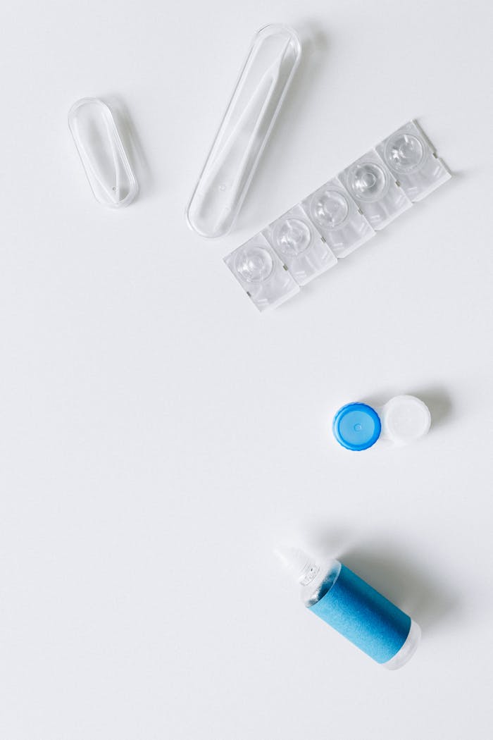 Contact lens essentials including solution bottle and storage cases on a clean white background.